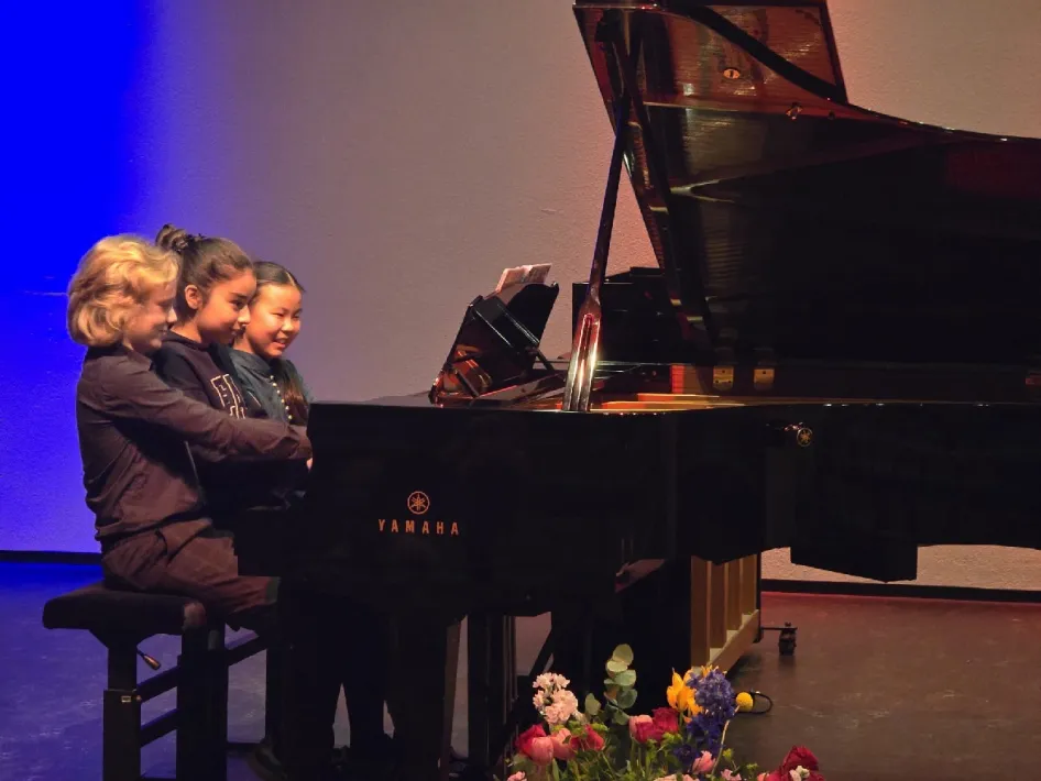 3 kids op een piano tijdens een concert