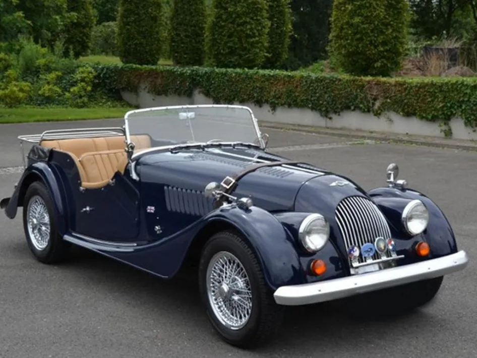 Klassieke cabriolet geparkeerd op een plein tijdens classic day, met donkerblauwe lak en beige interieur