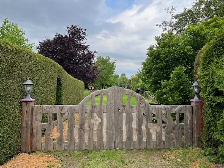 Houten tuinpoort tussen groene hagen tijdens de Open Tuinendag in Baarlo.