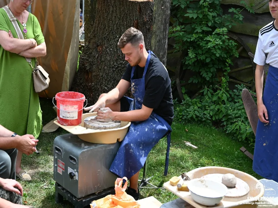 Pottenbakker werkt met klei tijdens Vlasdag met kantklossen, weven en pottenbakken bij Eynderhoof.
