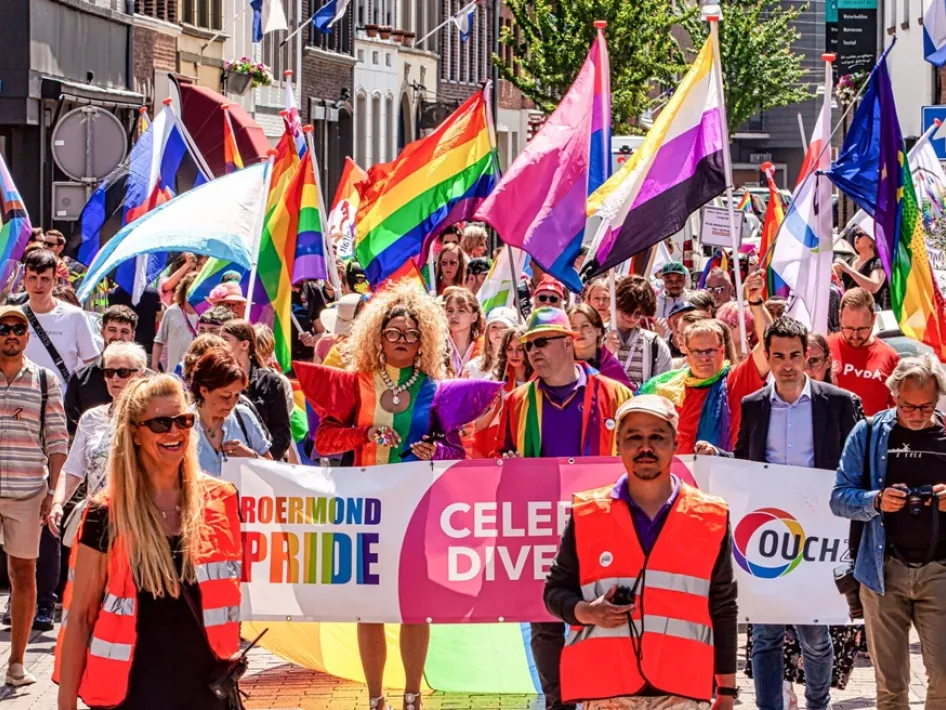 Roermond Pride Walk met een kleurrijke stoet deelnemers die met vlaggen en spandoeken door het centrum lopen tijdens een feestelijke en zichtbare demonstratie.