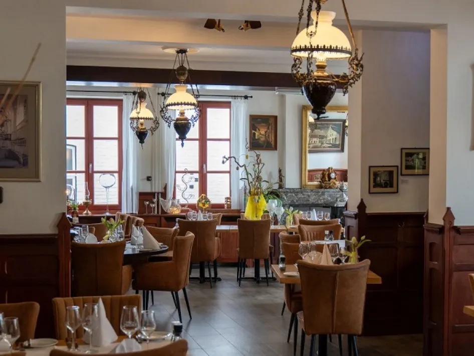 Sfeervol restaurantinterieur met gedekte tafels, stoelen en hanglampen bij restaurant Crasborn