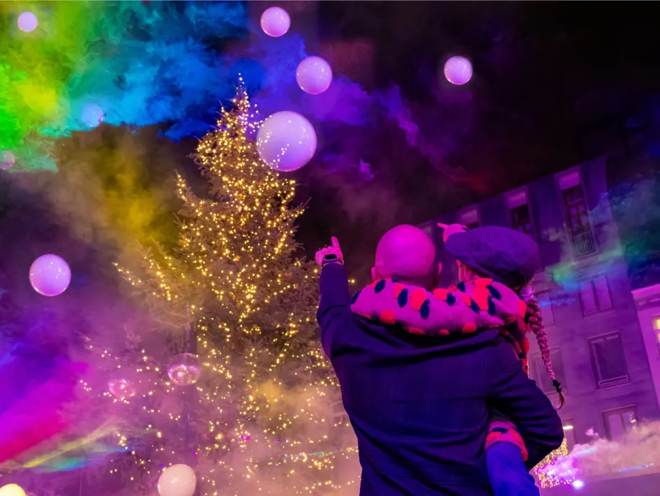 Bezoekers kijken naar een verlichte kerstboom tijdens Roermond vol Licht.
