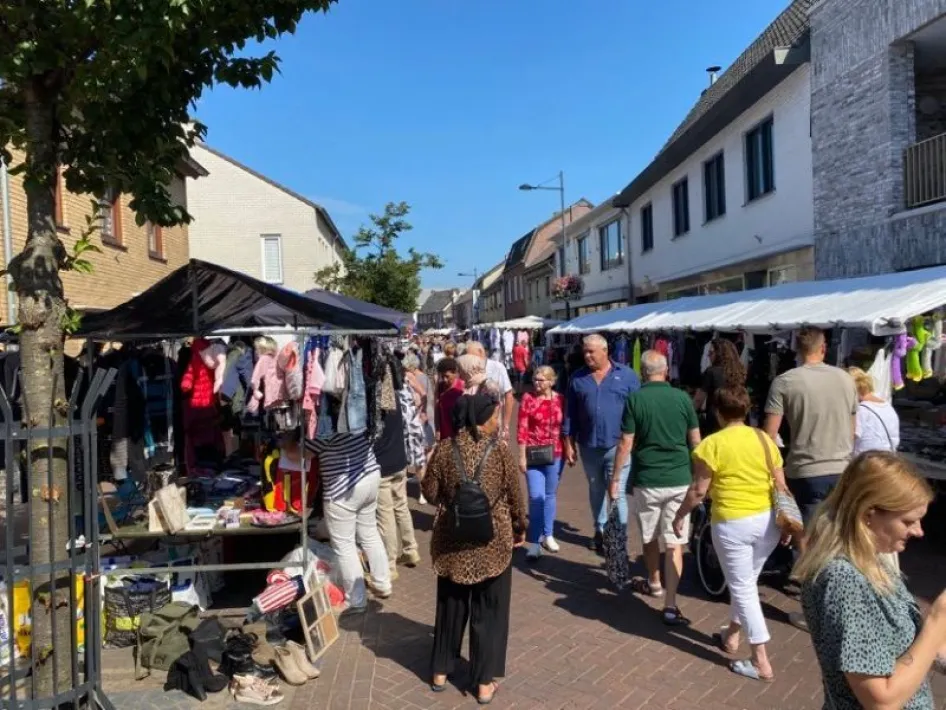 Voorjaarsmarkt Weert met kramen vol kleding en bezoekers die wandelen door het centrum op een zonnige dag