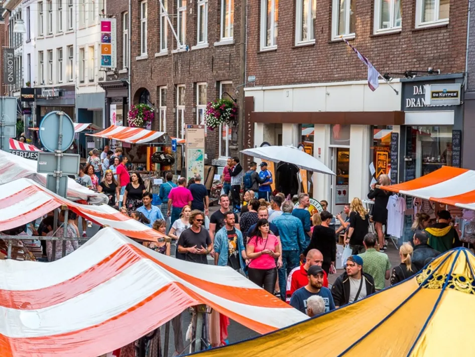 Drukke Sjoemelmert in Roermond met kraampjes, bezoekers, boeken, platen en muziek in de binnenstad.