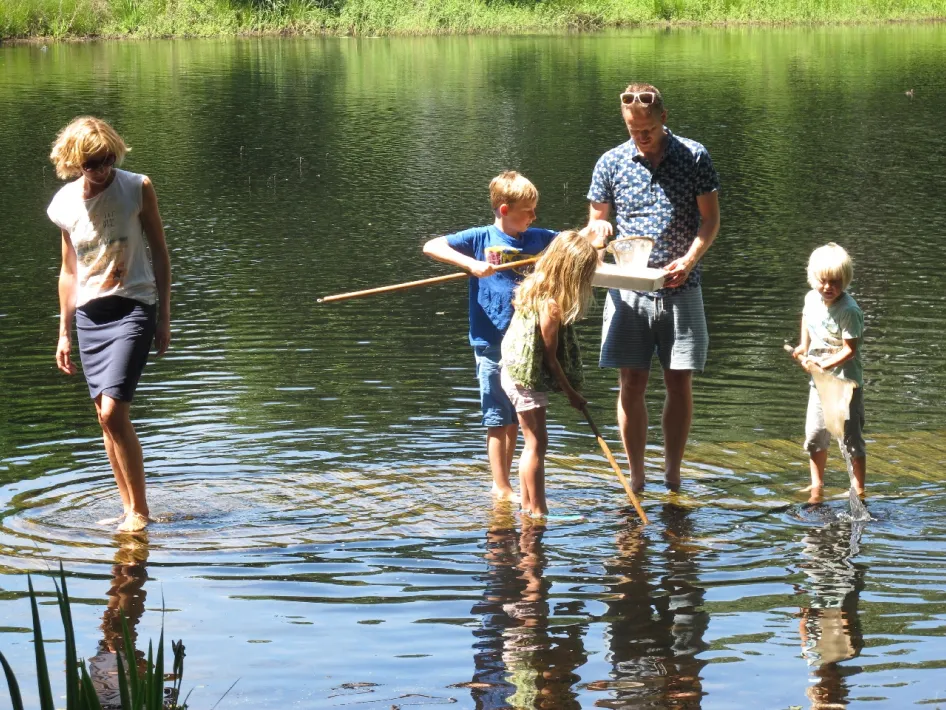 slootjesdag roermond waar een familie in het water staat