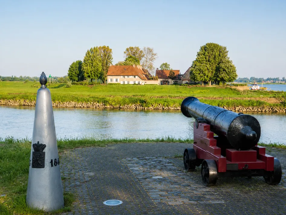Excursie langs het Eiland in de Maas met kanon, water en groen landschap bij Stevensweert.