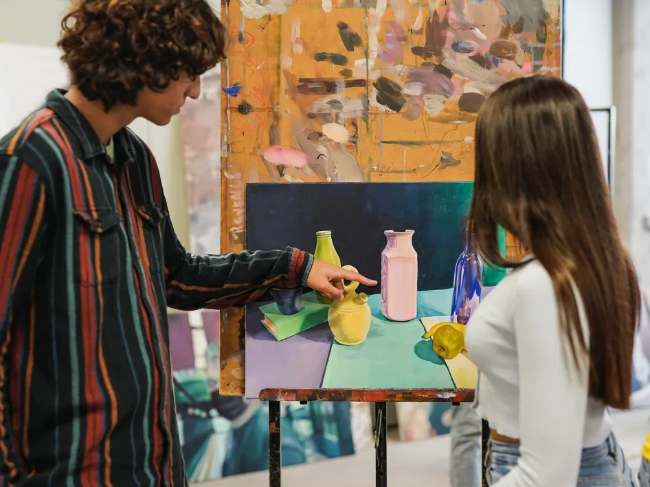 Bezoekers bekijken kunstwerken tijdens Art in the Yard en staan samen bij een kleurrijke installatie.