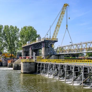 Stuw in Linne met stromend water en een zomers landschap op de voorgrond.