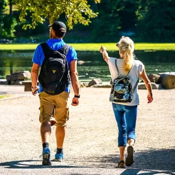Man en vrouw wandelen bij de Hariksee tijdens een van de mooie zomerwandelingen in Hart van Limburg