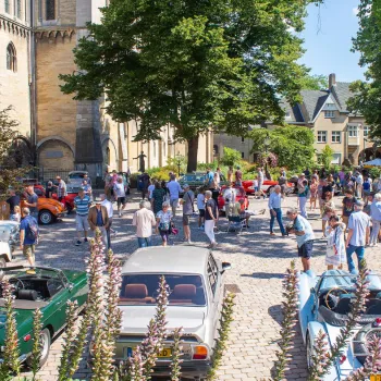 Sfeervol overzicht van klassieke auto's en bezoekers tijdens Roermondvol Oldtimers op het Munsterplein in Roermond.