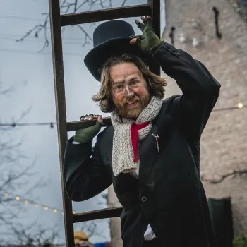 Figurant in Anton Pieck-stijl met hoge hoed en ladder tijdens het Eynder Pieck Festeyn in openluchtmuseum Eynderhoof.