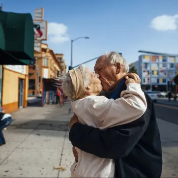 Twee oudere mensen zoenen elkaar op straat, als voorbeeld van het thema van de tentoonstelling Grijs! Art on Aging.