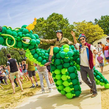 Mensen poseren op een terrein bij een draak gemaakt van ballonnen tijdens BillyBirds Zomerweken
