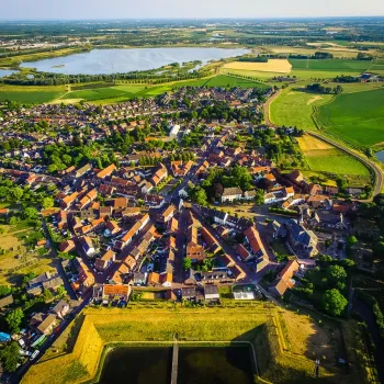 Luchtfoto van Stevensweert met het historische stratenpatroon en de vestingwerken waar je doorheen loopt tijdens de VVV-wandeling Stevensweert, gezien van boven.