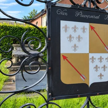 Smeedijzeren poort met familiewapen bij een historisch graf in Vlodrop, een van de plekken die aan bod kunnen komen tijdens de VVV-wandeling Vlodrop.