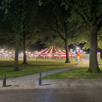 Gezellig verlicht festivalterrein in het Fatimapark in Weert, met een rood-witte feesttent en kleurrijke lichtjes tussen de bomen tijdens het Zomerfeest in het Fatimapark in Weert.