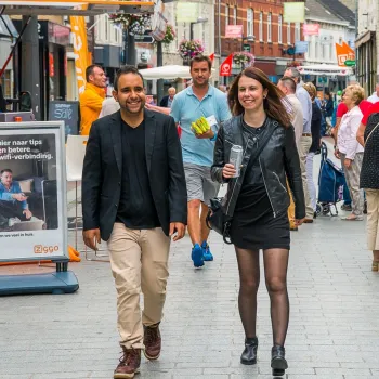 Twee bezoekers wandelen over de Braderie Weert in de sfeervolle binnenstad van Weert.