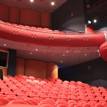 Binnenkant van het Munttheater in Weert met zitplaatsen van verschillende rangen.